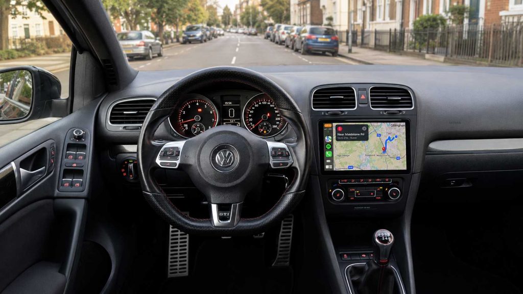 Інтер’єр VW Golf з установленою 9-дюймовою сенсорною автомагнітолою, навігацією на екрані та міським середовищем за вікнами
