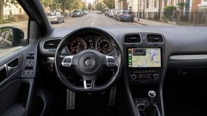 Інтер’єр VW Golf з установленою 9-дюймовою сенсорною автомагнітолою, навігацією на екрані та міським середовищем за вікнами
